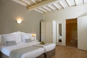 a bedroom with two beds and a bathroom at Hôtel Belesso in Fontvieille