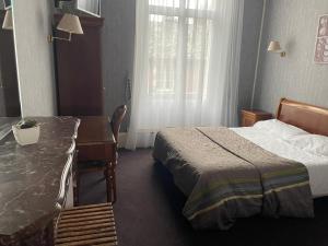 una camera d'albergo con letto, scrivania e finestra di Hotel La Poularde a Gien