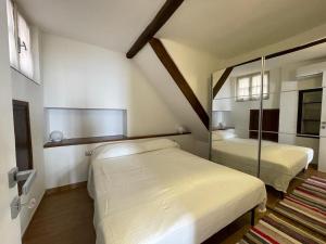 1 dormitorio con 2 camas y espejo en Nuovo Bilocale Frontemare, en Varazze