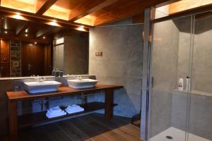 uma casa de banho com 2 lavatórios e um chuveiro em Hotel Rural El Portón de Murillo em Broto