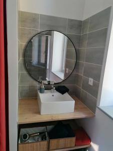 ein Badezimmer mit Waschbecken und Spiegel in der Unterkunft Gîte de l'Abbé 8 à 10 personnes in Lempaut + 12 Fotos