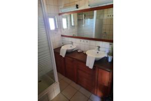 a bathroom with two sinks and a mirror at Ferienbungalow Waldstrasse in Ueckeritz