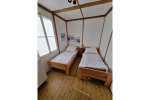 two beds in a room with a window at Ferienbungalow Waldstrasse in Ueckeritz