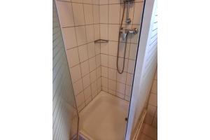 a shower in a bathroom with a tub at Ferienbungalow Waldstrasse in Ueckeritz
