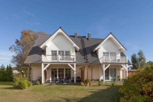 a large white house with a roof at Ferienwohung 3 Sandorn in Kölpinsee