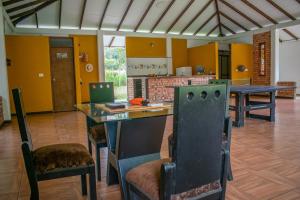 a kitchen with yellow walls and a table and chairs at Casa Finca Villa Cristal in Popayan