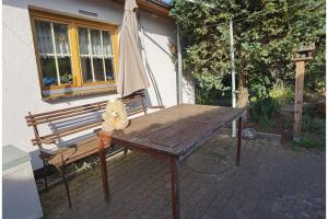 a teddy bear sitting on a wooden bench in front of a house at Ferienwohnung Hasenlodde in Loddin