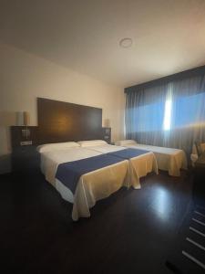 モネステリオにあるComplejo Leo 24Hの大きなベッドと窓が備わるホテルルームです。