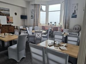 a restaurant with tables and chairs and a window at The Kenton Hotel in Scarborough