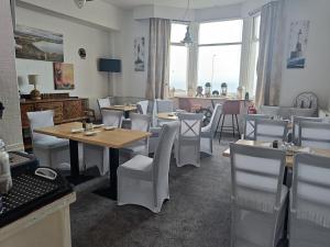 スカーバラにあるThe Kenton Hotelのテーブルと椅子、大きな窓のあるレストラン