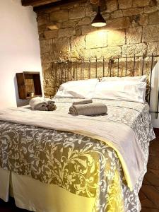 una camera da letto con un letto grande con un muro di pietra di La cicala a Rosignano Marittimo