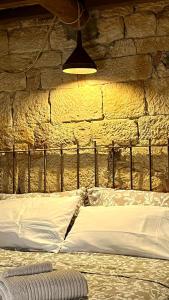 una parete in pietra con un letto in una stanza di La cicala a Rosignano Marittimo
