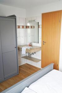 uma casa de banho com um lavatório e um espelho em Ferienhaus Strandlust em Baltrum