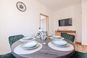 a dining room table with plates and wine glasses at Apartment Bojana in Petrcane