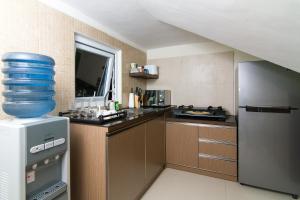 a small kitchen with a refrigerator and a counter at Rumah Kamang Residence in Jakarta