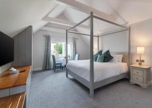 キラーニーにあるKillarney Heights Hotelのベッドルーム(天蓋付きベッド1台、テーブル付)