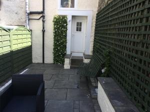 a bench in front of a building with a white door at Central Apartment Kelso in Kelso