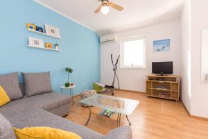a living room with a couch and a tv at Apartments Mirjana * central location and close to beach in Punat