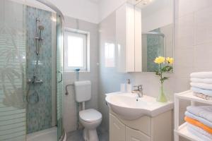 a bathroom with a toilet and a sink and a shower at Apartments Mirjana * central location and close to beach in Punat +36 photos