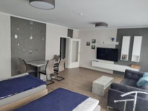 ein Wohnzimmer mit einem Bett, einem Tisch und einem TV in der Unterkunft Ferienwohnung in der Marktstraße in Mayen