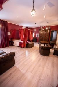 - une chambre avec des murs rouges, un lit et un canapé dans l'établissement Binario Magic RistoHotel, à Palazzago