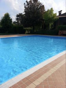 ein großer Pool mit blauem Wasser im Hof in der Unterkunft SUNFLOWER APARTMENT in Peschiera del Garda