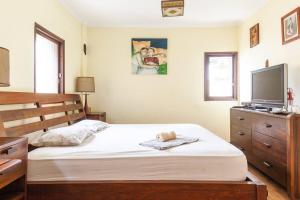 a bedroom with a bed and a flat screen tv at Cosy room near IDC & Center- Herzliya Homestay in Herzelia 