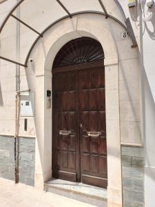 - une porte en bois dans un bâtiment avec une arche dans l'établissement La piccola Mimì, à Monopoli