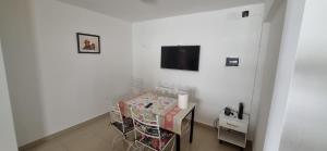 um quarto branco com uma mesa e uma televisão na parede em Atalaya em Salta