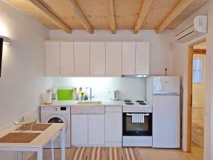 een keuken met witte kasten en een witte koelkast bij K-Homes Superior double in Tinos Town