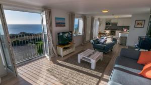 a living room with a view of the ocean at Chesil Beach Lodge Burton Bradstock Dorset DT64RJ in Bridport