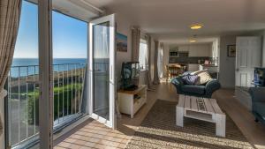 a living room with a view of the ocean at Chesil Beach Lodge Burton Bradstock Dorset DT64RJ in Bridport