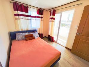 a bedroom with a large orange bed and a window at Zenmist Properties- 2 Bedroom Deluxe in Baguio