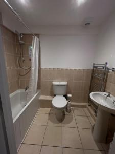 y baño con aseo, bañera y lavamanos. en Ground floor apartment, central location with free parking en Hereford