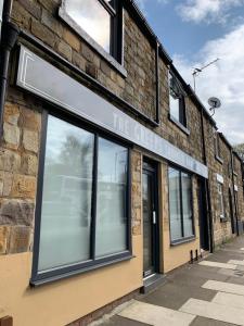 un edificio di mattoni con un cartello che legge la fabbrica di torte di The Greens Apartment a Farnworth