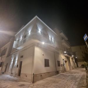 a white building with a balcony at night at Il civico storico in Brindisi