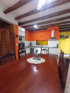 a kitchen with a wooden table and a kitchen with orange walls at La Josefina. in Maipú