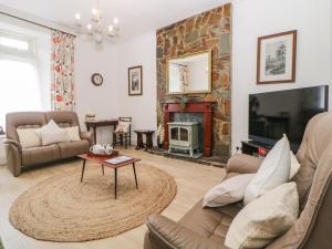 a living room with a couch and a fireplace at Harmony House in Yelverton