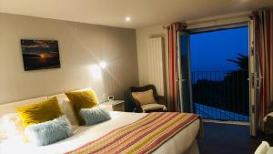 a hotel room with a bed and a balcony at Chesil Beach Lodge Burton Bradstock Dorset DT64RJ in Bridport