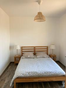Bett in einem Zimmer mit zwei Nachttischen und zwei Lampen in der Unterkunft Charmante villa avec studio indépendant in Vendays-Montalivet