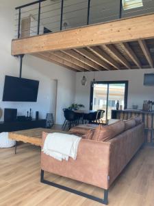 een woonkamer met een bank en een tafel bij Charmante villa avec studio indépendant in Vendays-Montalivet