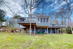 a large house with a deck on top of it at Woods Hole Hideaway in Falmouth