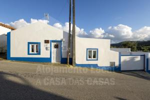 a white and blue building with a blue door at Casa Aconchego by AcasaDasCasas in Mafra
