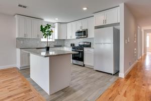 uma cozinha com armários brancos e um frigorífico branco em Stylish Newark, New Jersey, Vacation Rental! em Newark