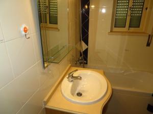 y baño con lavabo y bañera. en Apartamentos Carolino, en Monte Gordo