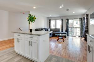 a kitchen with white cabinets and a living room at Stylish Newark, New Jersey, Vacation Rental! in Newark