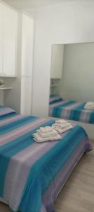 three beds in a room with towels on the bed at La casina di Ale in Marina di Carrara