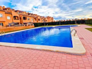 - une grande piscine bleue dans une cour avec des maisons dans l'établissement 2Bdr Apartment, à Torrevieja
