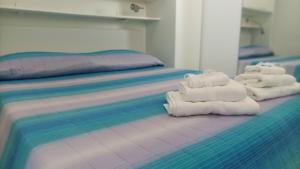 - 2 lits avec des serviettes pliées au-dessus dans l'établissement La casina di Ale, à Marina di Carrara