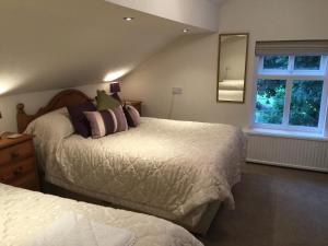 a bedroom with two beds and a mirror at Meadowcroft Guest House in Windermere